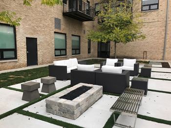 Beautifully landscaped courtyard with community seating and a cozy fire pit—your outdoor living room.